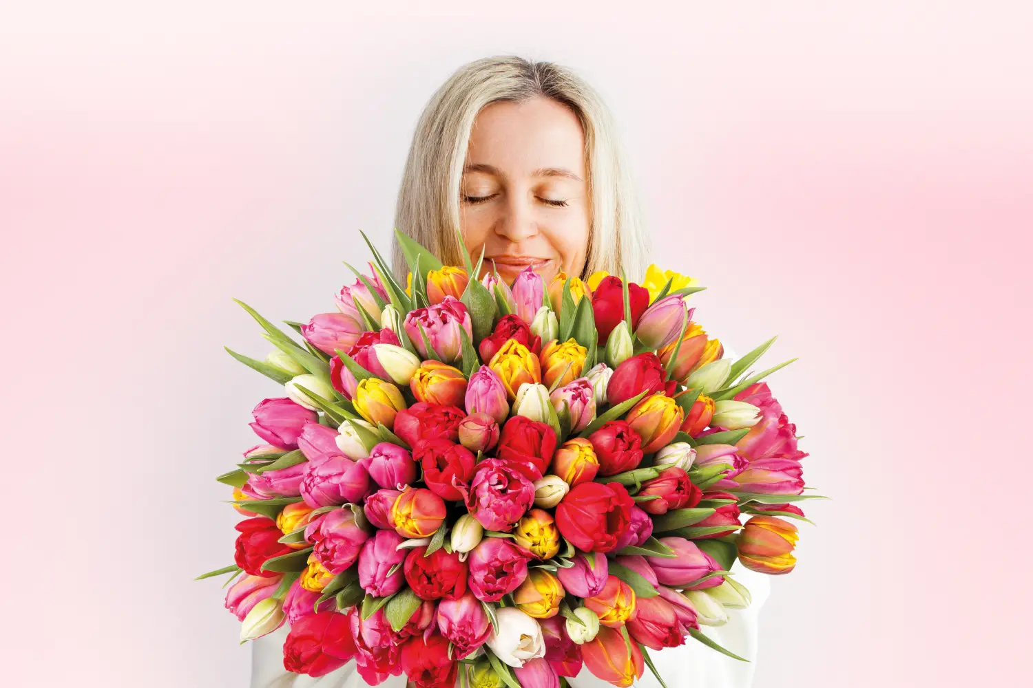 Frau freut sich über bunten Strauß voller Tulpen. Frau freut sich über bunten Strauß voller Tulpen.