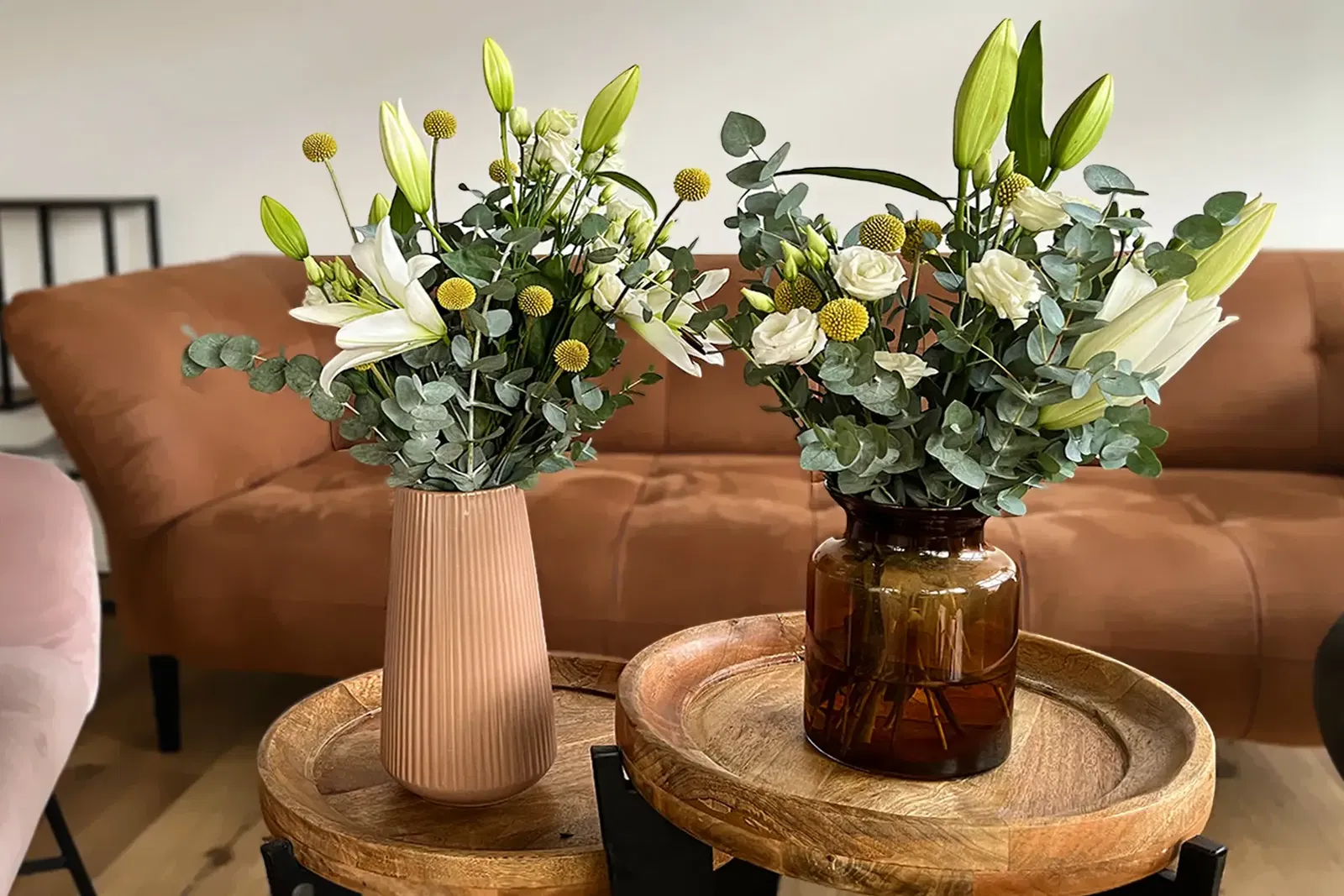 Zwei winterliche Sträuße mit Amaryllis, Eukalyptus und weißen Rosen in einem Wohnzimmer Zwei winterliche Sträuße mit Amaryllis, Eukalyptus und weißen Rosen in einem Wohnzimmer