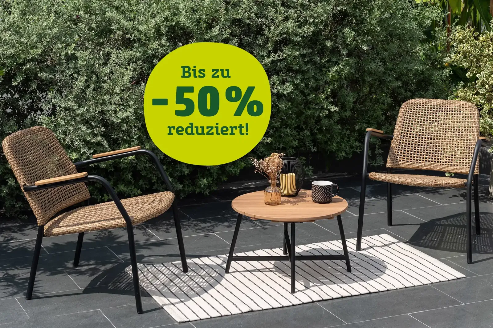 Gartenmöbel Bistro-Set Naga auf einer Terrasse mit dem Hinweis bis zu - 50 % reduzierte Gartenmöbel-Artikel